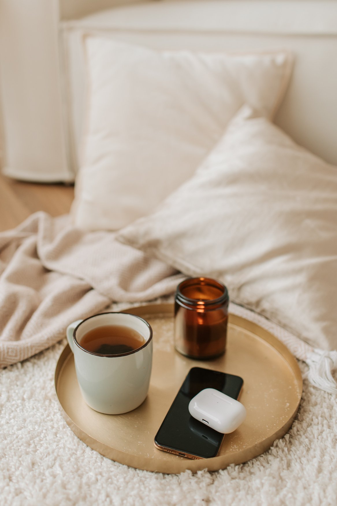 Gadgets, Scented Candle and Cup of Tea on Bronze Tray